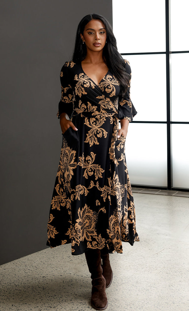 Size 10 woman wears the Portia Dress with brown knee-high boots..