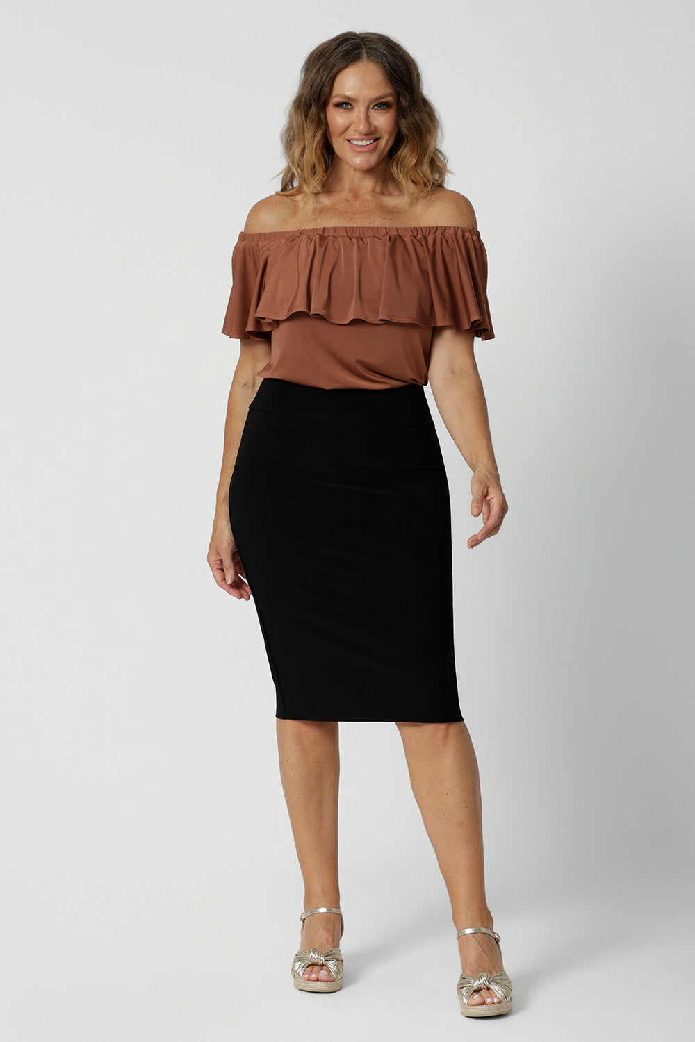 An off-the-shoulder top for summer, this slinky jersey top is a good top for over 40s style. Shown on a size 12 woman, this easy-care top is worn with a knee length, tube skirt. Made in Australia by Australian and New Zealand women's clothing brand, Leina & Fleur. Shop petite to plus size tops online for summer.