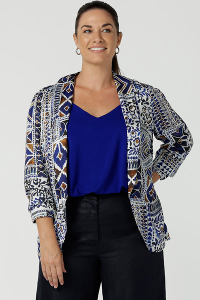 A curvy size 12 woman wears a soft tailoring summer blazer in printed Italian Viscose fabric. A breathable, lightweight women's jacket that's perfect for summer, this Mediterranean-inspired blazer is made in Australia by Australian and New Zealand women's clothes brand, Leina & Fleur.