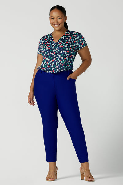 A size 18 woman wears cobalt blue tailored work pants with a bubble spot print, short-sleeve top. Showing a great plus size workwear outfit for women, these stretch-fit pants are made in Australia by Australian and New Zealand women's clothing company, Leina & Fleur. 