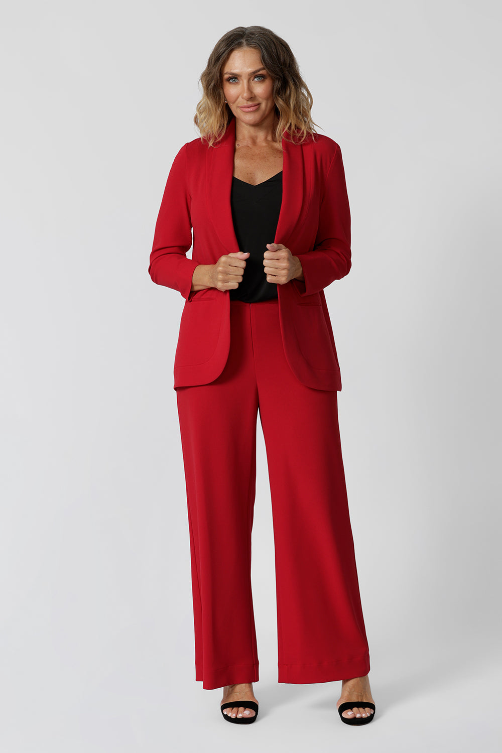 Showing a red suit for women , an over 40s women wears a red high waisted pant with wide legs. Made in Australia for by Australian-made fashion brand, Leina & Fleur. Stylish corporate wear for women. Made in Australia size 8 - 24.