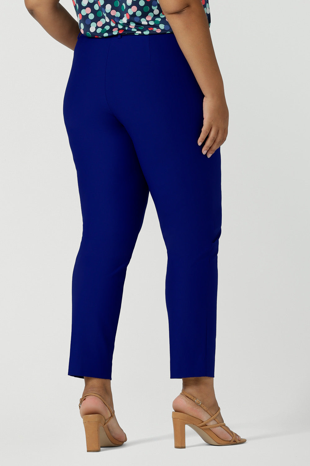 Back view of cobalt blue tailored pants shown on a size 18, curvy woman. Great pants for plus size women, wear these stretch-fit tapered leg trousers for work or as smart-casual pants for the weekend. Made in Australia, these women's trousers are available to shop in sizes 8 to 24.