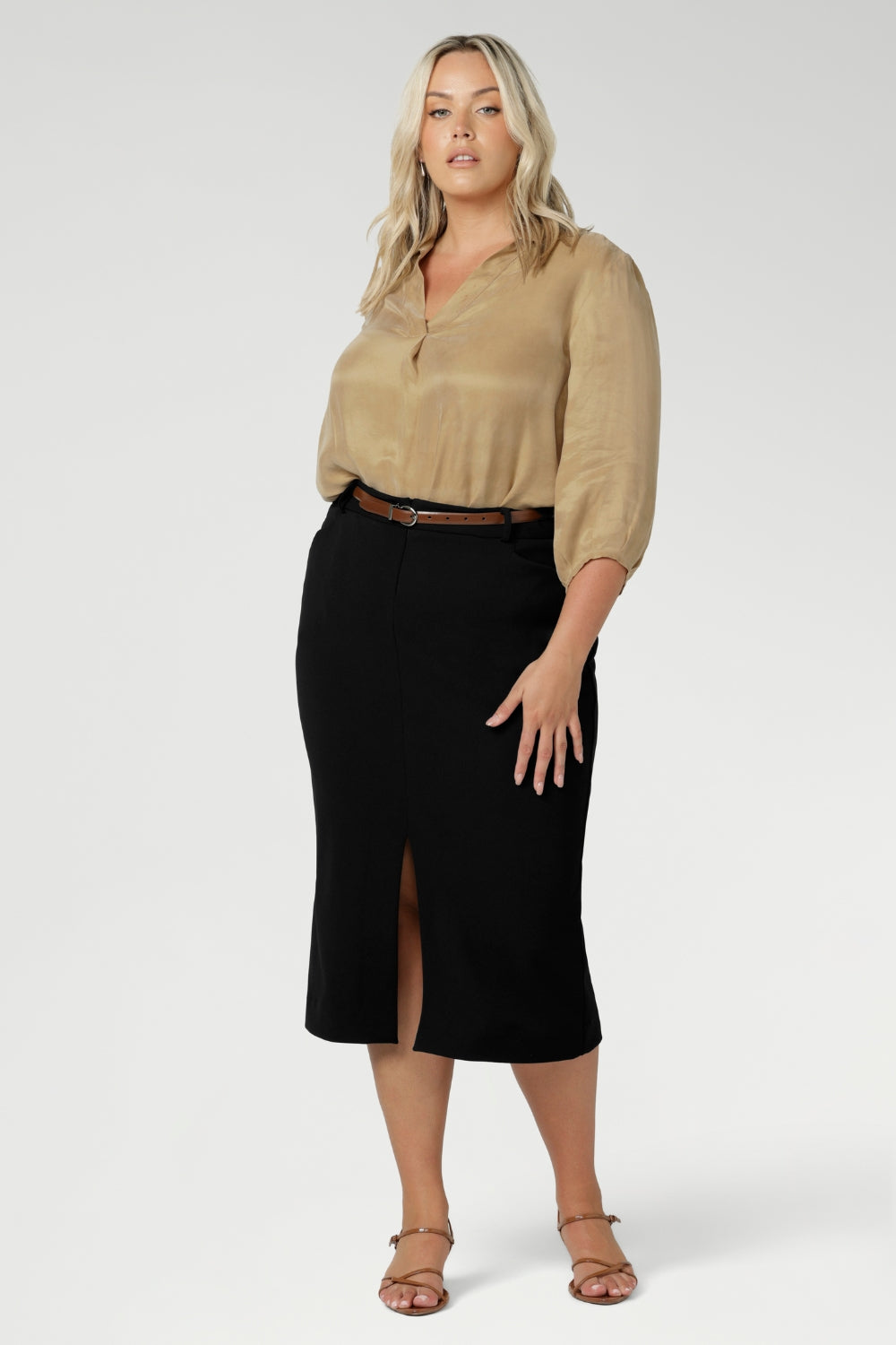This stretchy, easy-care skirt is a perfect workwear piece for elevated suit styling with matching jacket or blazer. Size 18 model wears her midi length workwear skirt with brown kitten heels and a gold collared blouse.