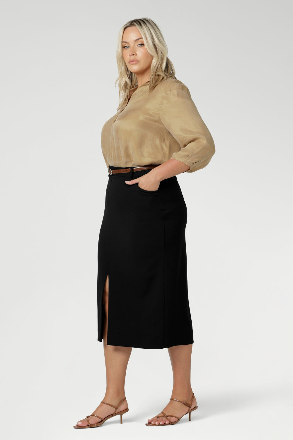 This stretchy, easy-care skirt is a perfect workwear piece for elevated suit styling with matching jacket or blazer. Size 18 model wears her midi length workwear skirt with brown kitten heels and a gold collared blouse. Available in sizes 8-24.