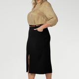 This stretchy, easy-care skirt is a perfect workwear piece for elevated suit styling with matching jacket or blazer. Size 18 model wears her midi length workwear skirt with brown kitten heels and a gold collared blouse. Available in sizes 8-24.