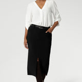 Australian made black workwear skirt seen on over 40's woman paired with opal coloured shirt and black heels for an elevated workwear look. Sizes 8-24 available at Leina & Fleur.