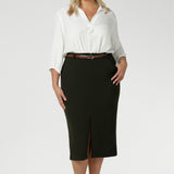 Plus size woman wears Australian made Olive workwear skirt seen on plus size woman paired with white blouse and brown kitten heels for an elevated workwear look. Sizes 8-24 available at Leina & Fleur.