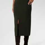 Close up image of Made in Australia by Australian and New Zealand women's clothing brand, Leina & Fleur. This stretchy, easy-care skirt is a perfect workwear piece for elevated suit styling with matching jacket or blazer. Size 10 model wears her midi length workwear skirt with long boots and a black blouse.