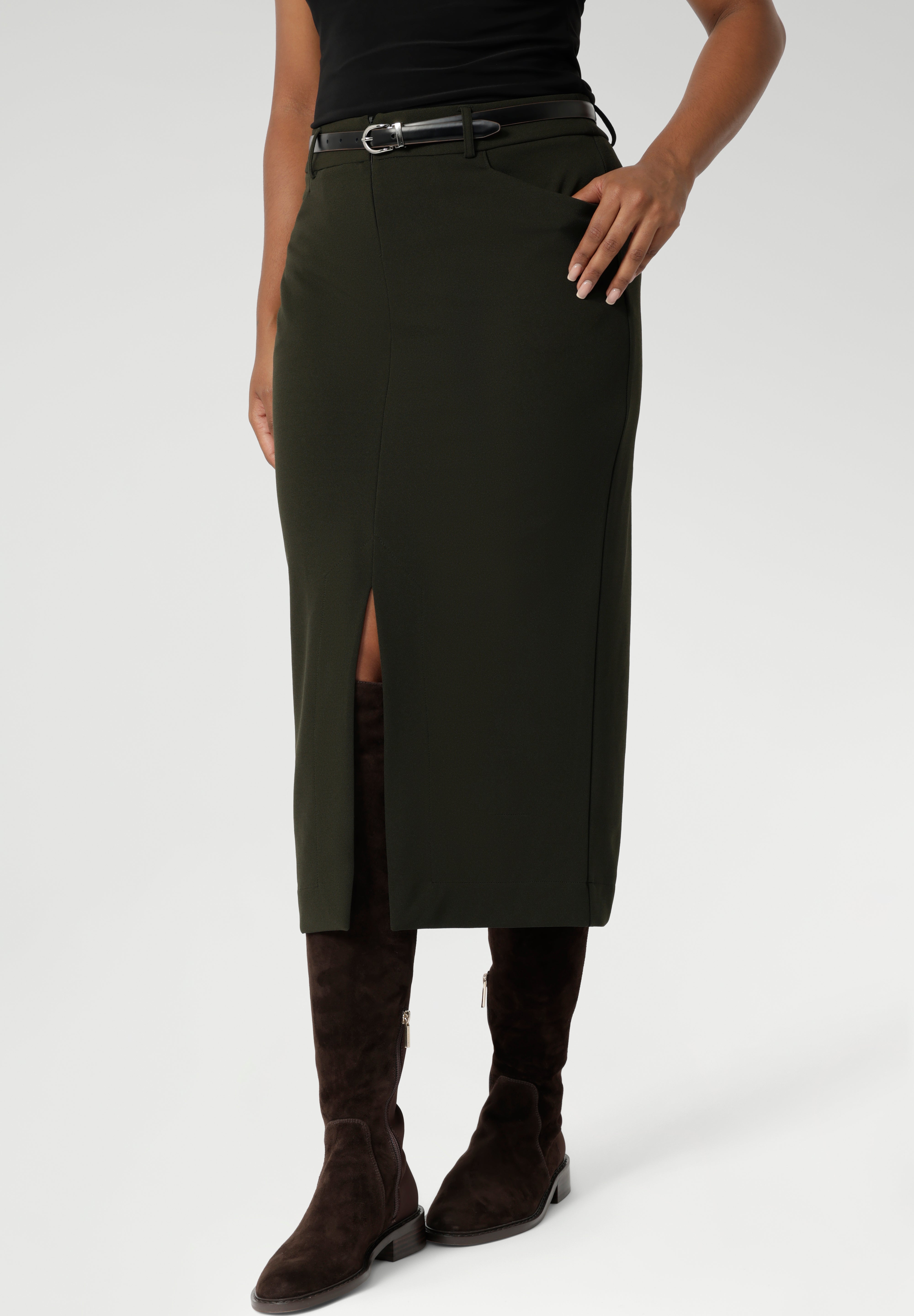 Close up image of Made in Australia by Australian and New Zealand women's clothing brand, Leina & Fleur. This stretchy, easy-care skirt is a perfect workwear piece for elevated suit styling with matching jacket or blazer. Size 10 model wears her midi length workwear skirt with long boots and a black blouse.