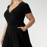 The functioning wrap design features an elegant double-layer back bodice and extended waist ties for a flattering fit. Short sleeves with tucks at the sleeveheads add a touch of detail, while the A-line skirt enhances its feminine silhouette. With side pockets for added practicality, this midi-length dress is an ideal choice for curvy women seeking stylish workwear. Available in sizes 8-24, the Alexis dress is the perfect plus-size wrap dress for women looking for a flattering, functional, and fashionable