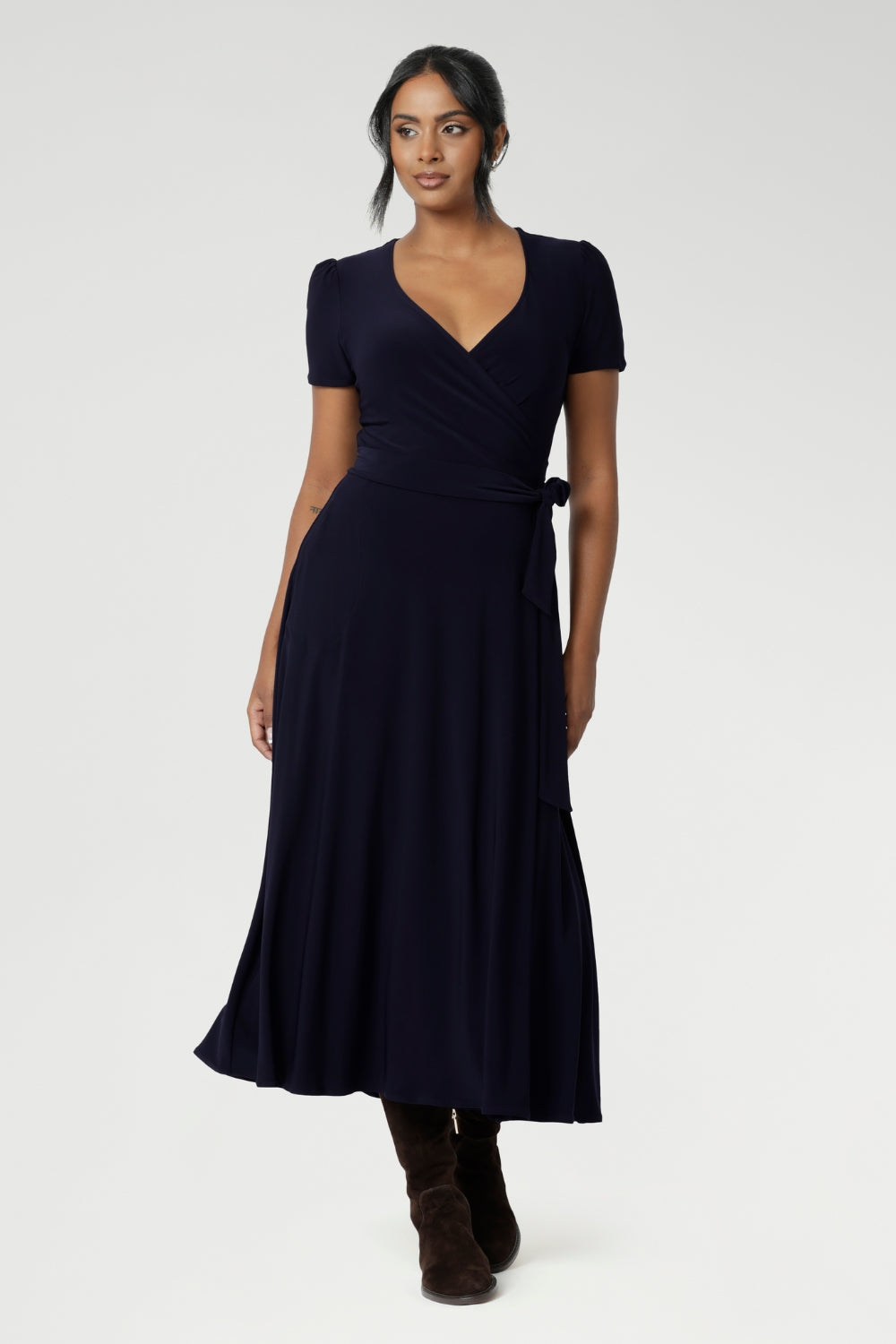 A curvy, size 18 woman wearing a navy, wrap dress with short sleeves. A great dress for summer casual wear, or for travel. Shop made in Australia dresses in petite to plus sizes online at Australian fashion brand, Leina & Fleur.