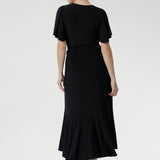 Black jersey wrap dress with extended waist ties, sweetheart neckline, and feminine flutter sleeves — perfect for events and celebrations.