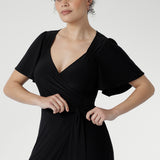 Glamorous Alita Black Wrap Dress with sheen finish, deep hem ruffle, and flattering wrap silhouette for special occasions.