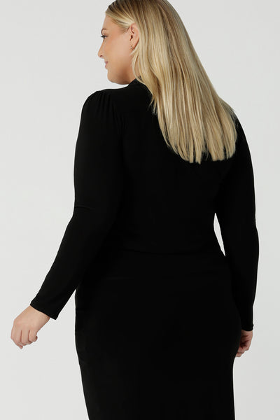 Back view of a size 18 woman wears the Thom top in Black a tie neck top with a V-neckline. Made in comfortable jersey have and made in Australia for women size 8 - 24.