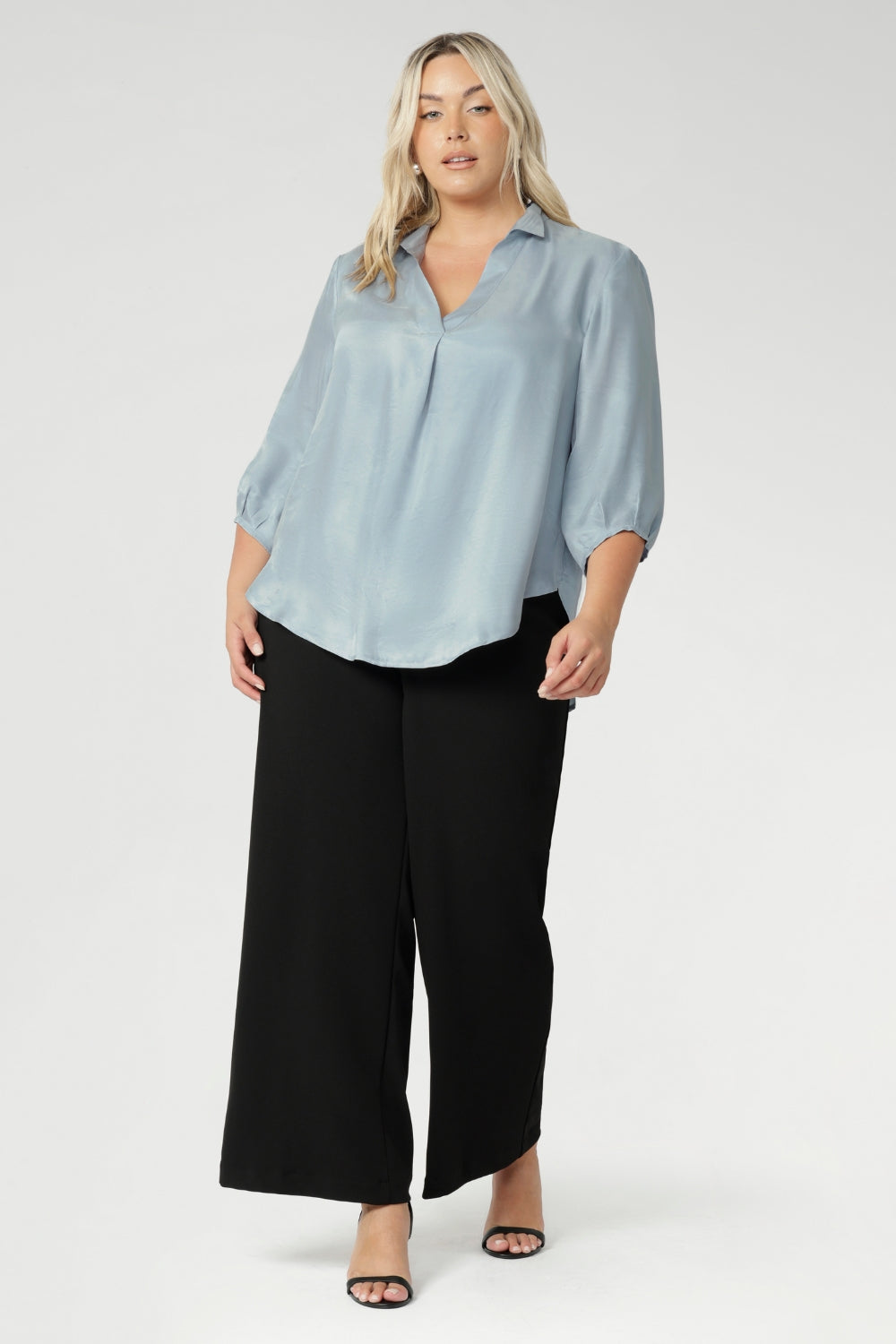 Crafted in an easy-care woven fabric and made in Australia for women across Australia and New Zealand in sizes 8 to 24. The Arley Shirt delivers comfort and easy elevated dressing. Plus size woman wears her Arley Shirt over black work pants.