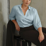This pull-on style combines a sleek, contemporary silhouette with thoughtful detailing, making it a go-to piece for effortless polish. Semi-fitted through the body, it features a classic collar neckline and subtle tuck details below the back neckline, adding gentle structure without compromising comfort. The ¾ length sleeves fall softly and are finished with narrow bound hems, bringing a refined finish to a relaxed shape. A curved shirttail hemline completes the look.