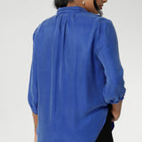 The semi-fitted shape creates a flattering line through the body, while the classic collar adds a sharp, structured touch. Soft tuck detailing below the back neckline introduces gentle shape and subtle interest, complemented by ¾ length sleeves with neatly bound hems for a polished finish.