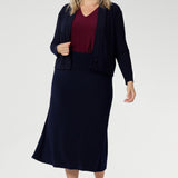 Australian-made midi skirt is crafted from a soft-touch jersey fabric, offering a lightweight feel that's perfect for all-day comfort. Plus size model wears travel ready skirt in deep navy colour paired with ruby coloured top and navy sandro.