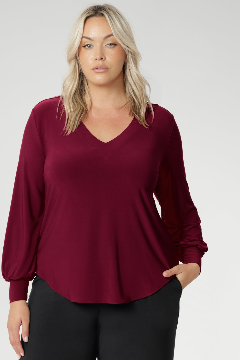 The Avery Top in Ruby brings effortless elegance to your everyday wardrobe, combining tailored structure with luxurious comfort. Crafted in Australia from a soft-stretch, dry-touch jersey fabric, this vibrant red women's top delivers both style and wearability. The semi-fitted silhouette features long bell sleeves with cuffs that add a touch of drama, while still maintaining a polished, versatile look.