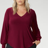 The Avery Top in Ruby brings effortless elegance to your everyday wardrobe, combining tailored structure with luxurious comfort. Crafted in Australia from a soft-stretch, dry-touch jersey fabric, this vibrant red women's top delivers both style and wearability. The semi-fitted silhouette features long bell sleeves with cuffs that add a touch of drama, while still maintaining a polished, versatile look.
