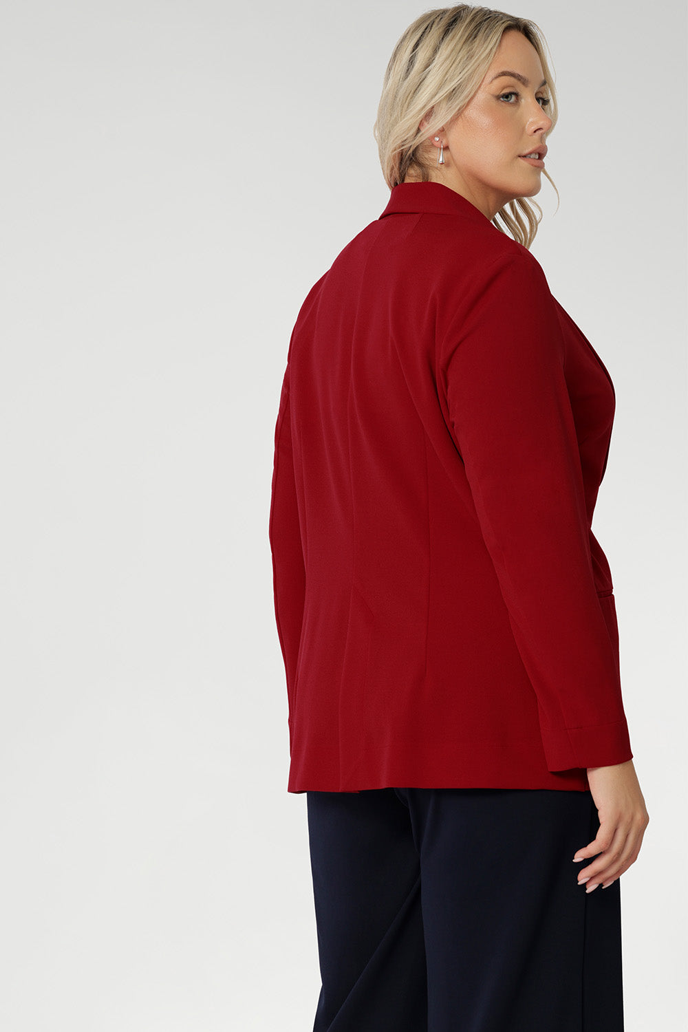 This red work blazer is worn with navy work pants. Curved hemline and front pockets. Made in Australia for women size 8 - 24. Red Blazer adds a vibrant colour to your wardrobe.