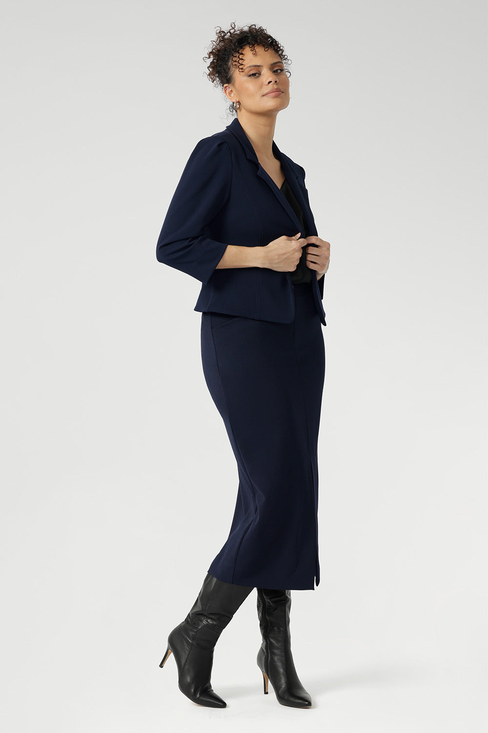 Inside, you'll find a practical phone pocket on the inner left side, perfect for easy access to essentials. The single-layer back is shaped with delicate darts that contour the figure, while the shoulder yoke adds a structured element to the overall design.