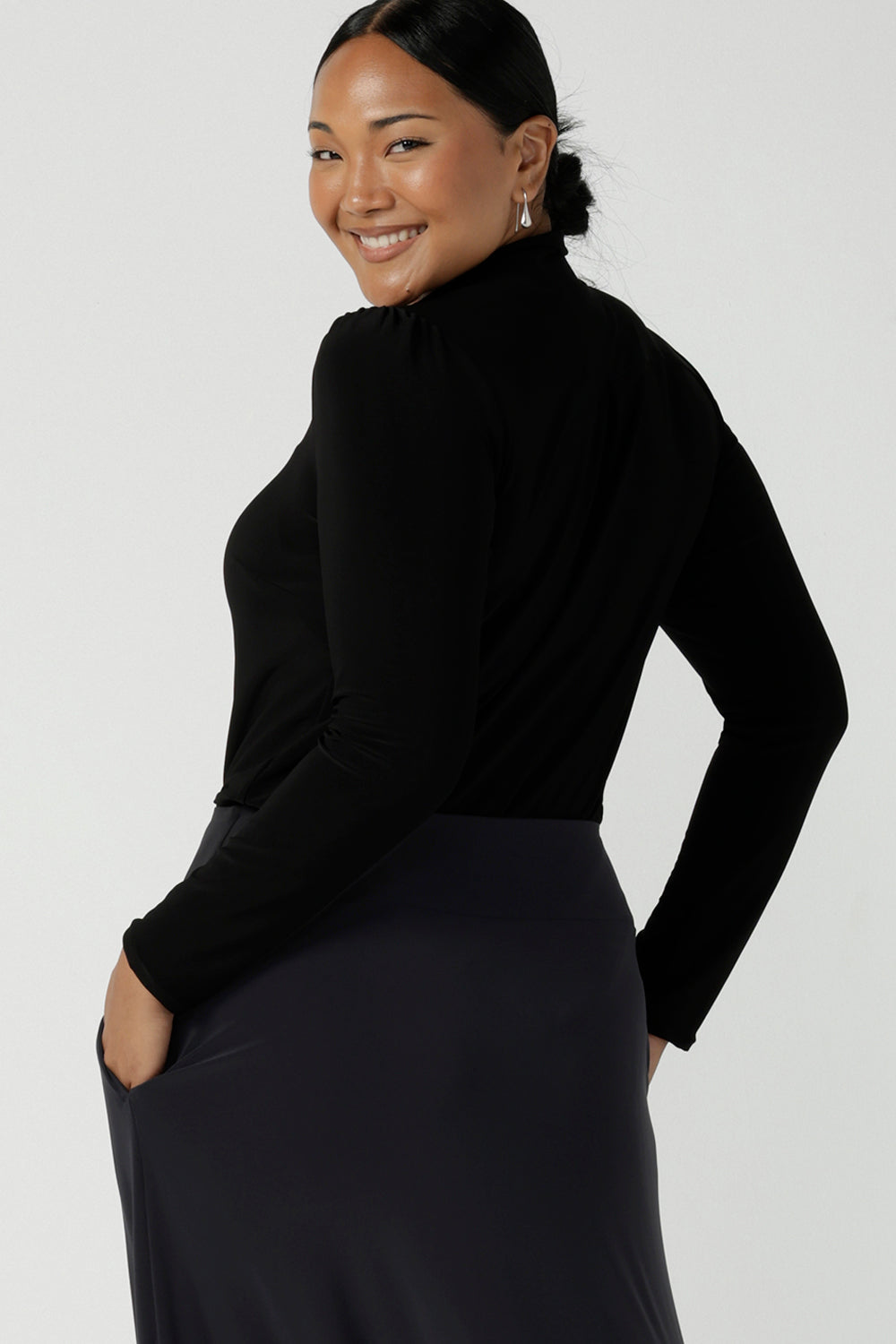 Back view of a size 12 woman wears the Thom top in Black a tie neck top with a V-neckline. Made in comfortable jersey have and made in Australia for women size 8 - 24.