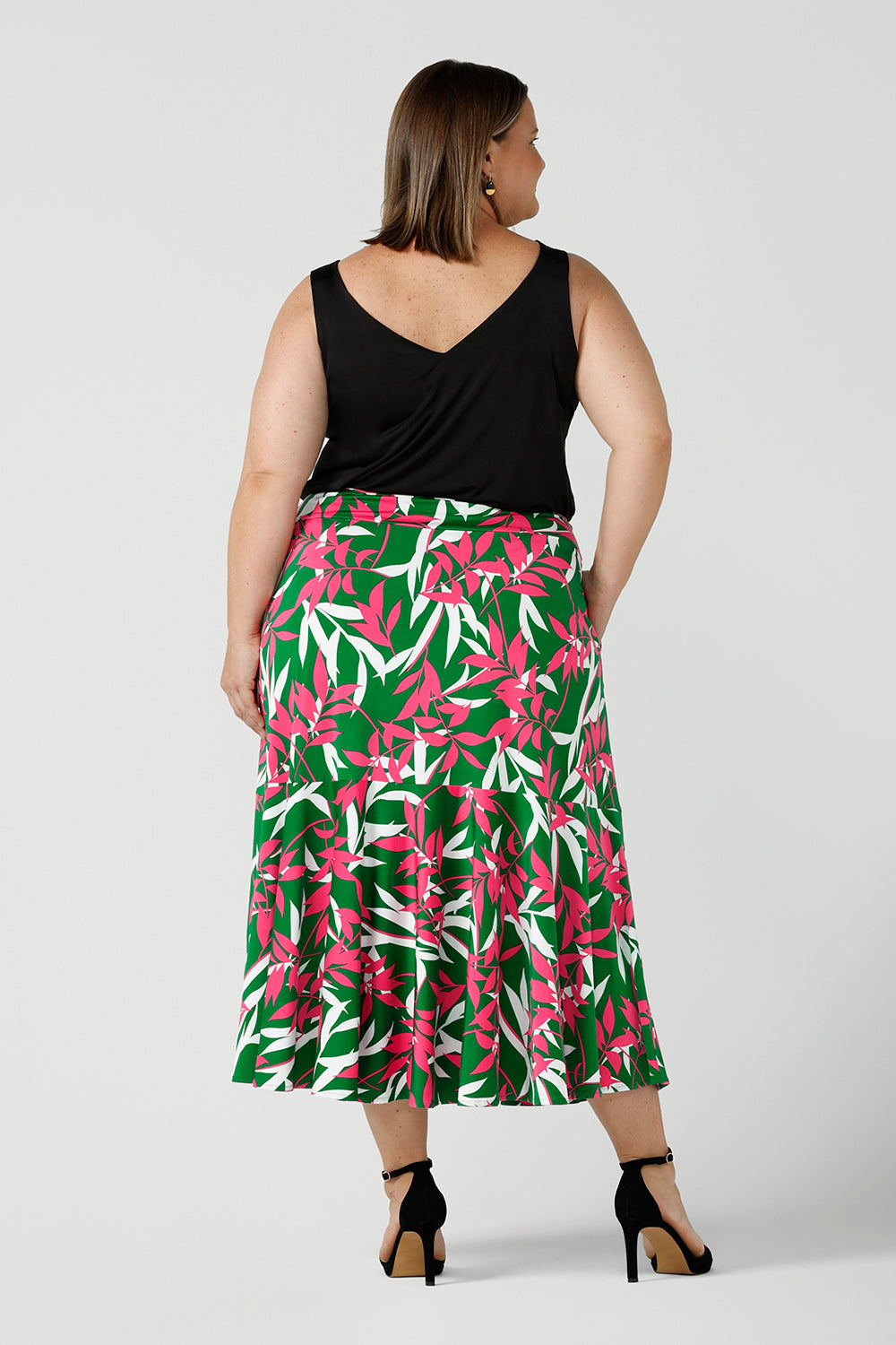 Back view of a curvy Woman in a size 18 wears a Verdant Green skirt. Midi jersey skirt with pockets. Size 8 - 24.