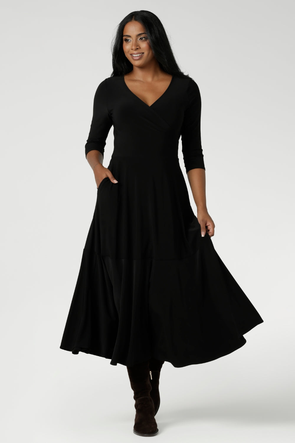 Over 30's woman wears Bettina Reversible Dress in Black. Australian made Jersey fixed wrap dress features a V-neck style with pockets and midi length. Made in Australia for women size 8-24. Reversible dress can be worn featuring both a boat neck or Vneck.
