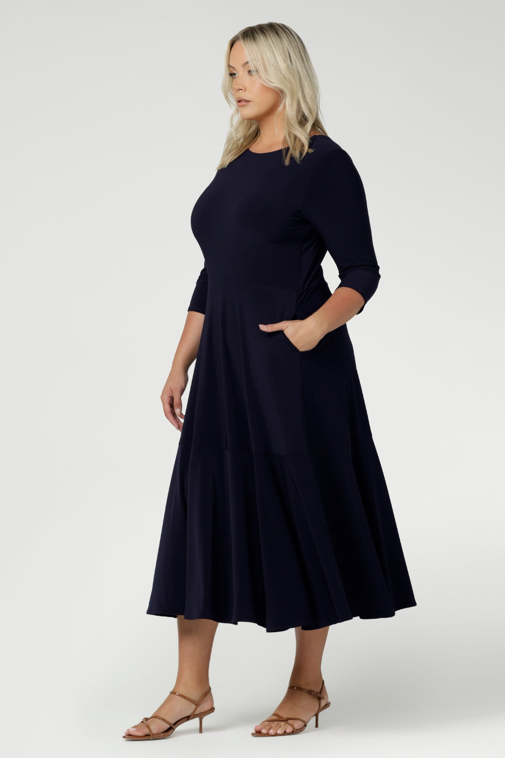 Close up of a size 18 woman wears a Bettina Reversible dress in Navy. Stylish workwear for women. Midi length with functional pockets. Made in Australia for women size 8 - 24. Soft Navy jersey fabric.