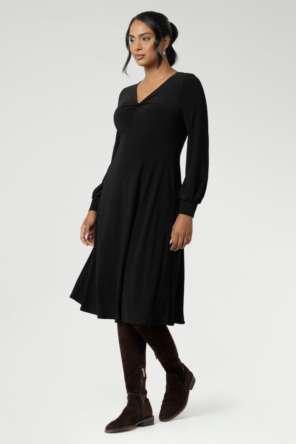 The Bianca Dress is a versatile wardrobe essential, designed to take you from work to events with effortless elegance. This classic black knee-length dress features a flattering V-neckline and a twist-front bodice that enhances your shape, while the cuffed long sleeves add a polished finish.