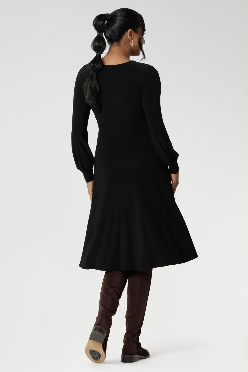 Featuring a sophisticated V-neckline with a twist-front bodice and cuffed long sleeves, it creates a flattering silhouette with elegant detail.