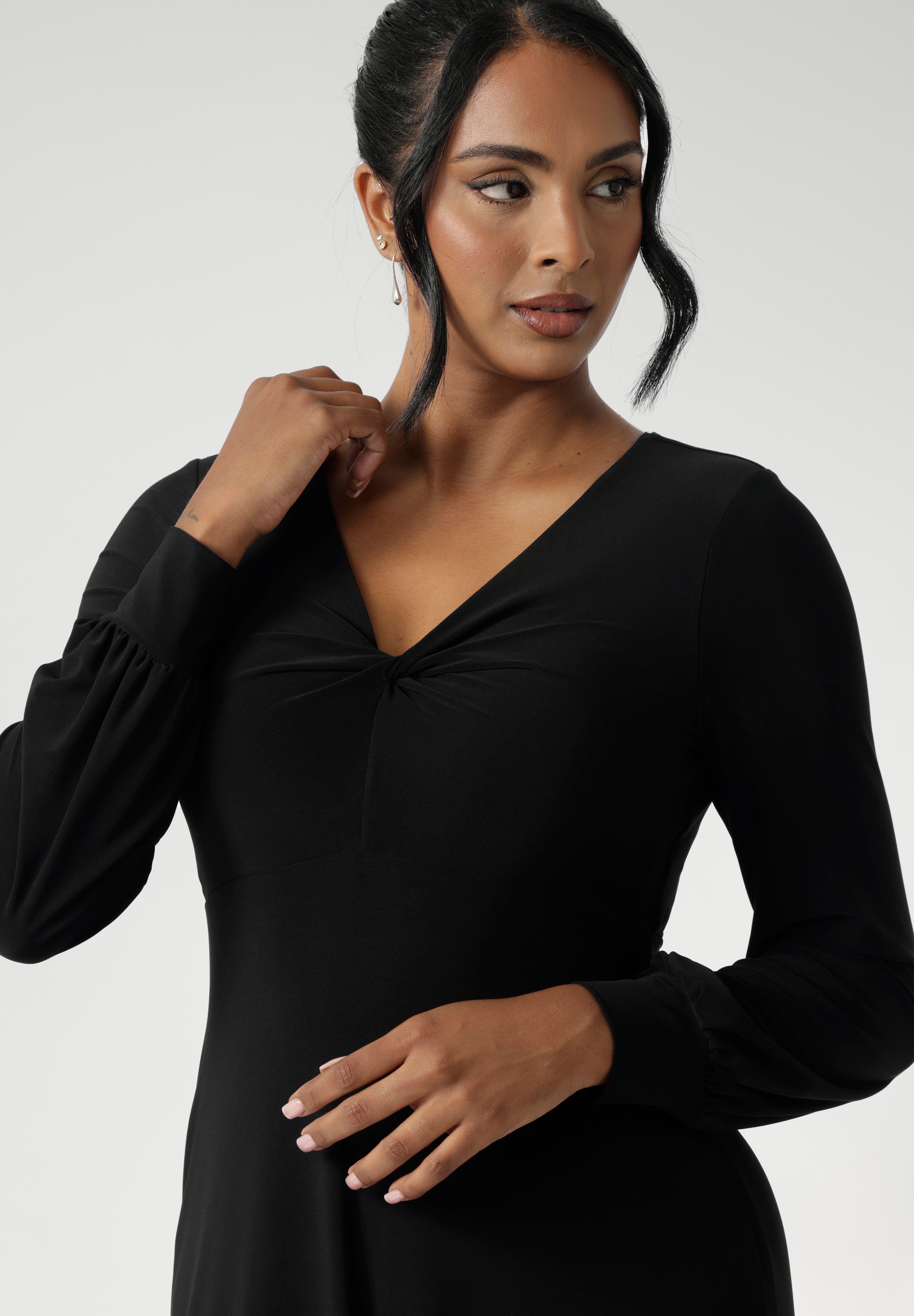 The Bianca Dress is a timeless black knee-length style designed for both work and special occasions. Featuring a sophisticated V-neckline with a twist-front bodice and cuffed long sleeves, it creates a flattering silhouette with elegant detail. Made in Australia from our signature dry-touch jersey fabric.