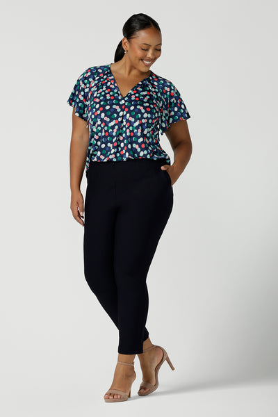 Back view of Curvy woman in a size 16 wears a Bowie top with a flutter sleeve and v-neck with neck ties. All over polka dot print on a soft slinky jersey. Comfortable work top for women. Made in Australia size 8 - 24.