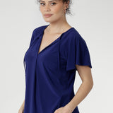 The Bowie Top in Sapphire is designed for comfort and confidence. Made from dry-touch jersey with soft stretch, it drapes beautifully in a relaxed fit with a flattering V-neckline, pleated front, and playful tie accents. Flutter sleeves and a shirttail hem add the perfect finishing touch for workdays or downtime alike.