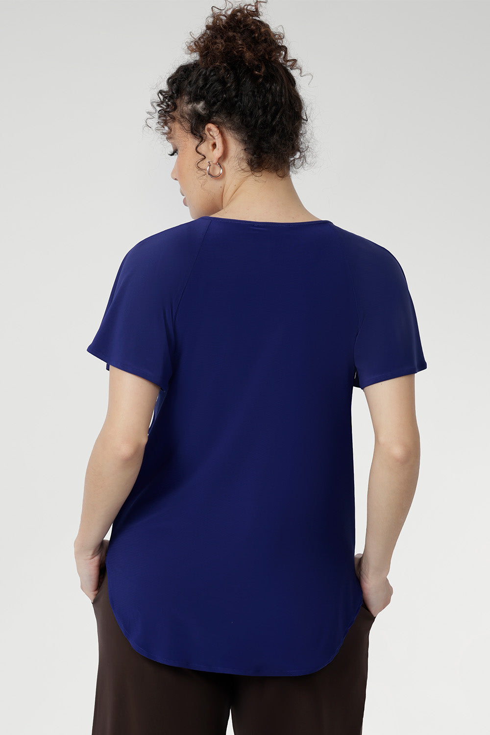 Tailored from smooth dry-touch jersey with comfortable stretch, the Bowie Top in Sapphire combines a relaxed fit with thoughtful detailing, a V-neckline, front pleats, and tie accents. Flutter sleeves and a softly curved shirttail hem complete this versatile, feel-good essential.