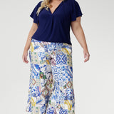Crafted from a dry-touch jersey with gentle stretch, the Bowie Top in Sapphire offers a relaxed silhouette complemented by a V-neckline, soft pleat detailing, and tie accents. Finished with flutter sleeves and a shirttail hem, it transitions effortlessly from weekday to weekend wear.