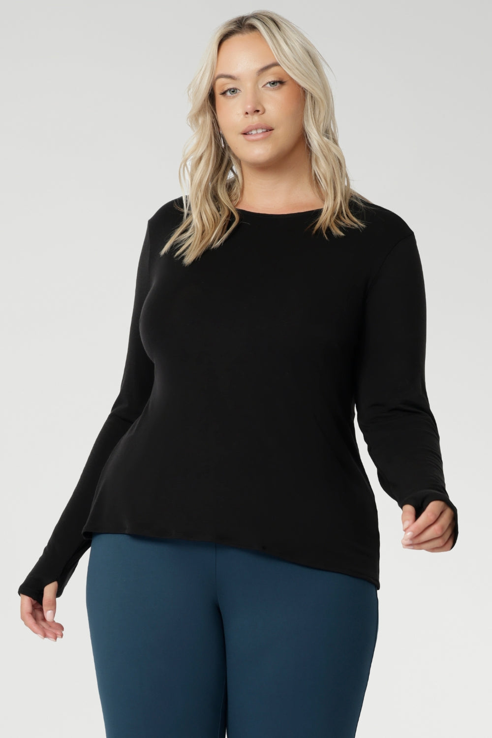 Designed for comfort and versatility, it features a flattering close-to-body fit that moves with you, thanks to its generous stretch and breathable finish. Size 18 model wears black knit top has thumbholes that can be used or tucked away for versatility in styling and extra warmth.