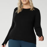 Designed for comfort and versatility, it features a flattering close-to-body fit that moves with you, thanks to its generous stretch and breathable finish. Size 18 model wears black knit top has thumbholes that can be used or tucked away for versatility in styling and extra warmth.