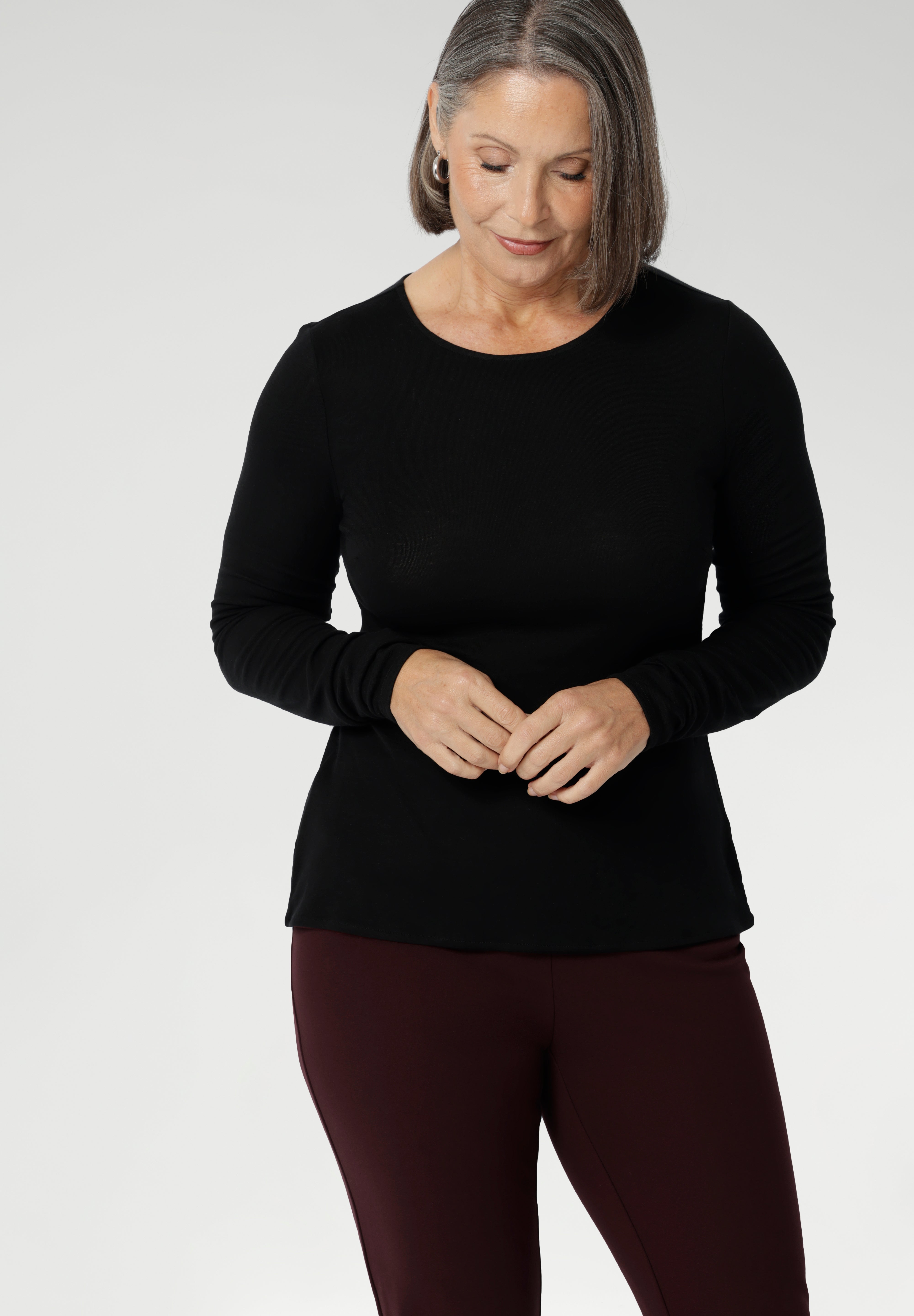 Stay effortlessly stylish through the cooler months with this luxuriously soft knit top, crafted from a premium Tencel wool blend. Designed for comfort and versatility, it features a flattering close-to-body fit that moves with you, thanks to its generous stretch and breathable finish. Black knit top has thumbholes that can be used or tucked away for versatility in styling and extra warmth.