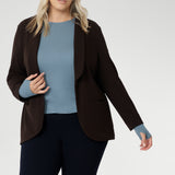 Featuring a classic round neckline and long sleeves, it’s designed with comfort in mind — offering generous stretch and a smooth, breathable feel, without the itch of traditional merino. Size 18 model wears cocoa Merit Blazer over wool top, paired with womens navy work pants.