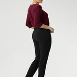 Woman wearing work wear pants in Black Scuba Crepe. This easy care pant is made of scuba crepe fabric and gives a luxe stretch feel. Comfortable off duty pants are made in Australia for women sized 8-24. Pants are photographed with matching black blazer for a full suit look.