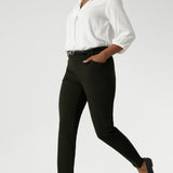 The pants are designed with angled front pockets, giving them a modern touch, while the back darts ensure a tailored fit that contours to the shape of the body. Size 10 woman wears her Corbin Pants with lightweight blouse and black loafers.