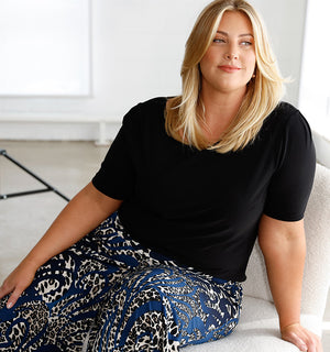 Highlighting Australian fashion brand, Leina & Fleur's sustainably made, slow fashion, a woman wears a limited edition navy blue jersey top with short sleeves, made in Australia.