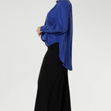 A size 10 woman wears black wide-leg pants made from easy care dry touch jersey. Cropped in length, the black pants have a smooth waistband, side pockets and are pull-on pants made in stretch jersey. Made in Australia, the pants are size inclusive in sizes 8 - 24.