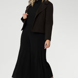 Plus size woman wears black culottes with black turtle neck & brown jacket. Stretch black pants for women, have a smooth waistband, side pockets and are a pull-on style. Made in Australia, from dry touch jersey fabric in sizes 8-24.
