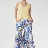 Crafted from our soft-touch stretch jersey, the Dany Culotte in Mosaic Tile captures the essence of Mediterranean elegance. Featuring an intricate Sicilian-style mosaic print in vibrant shades of cobalt, yellow, brown, and green on a crisp white base, these wide-leg culottes offer effortless movement and a beautifully fluid drape.