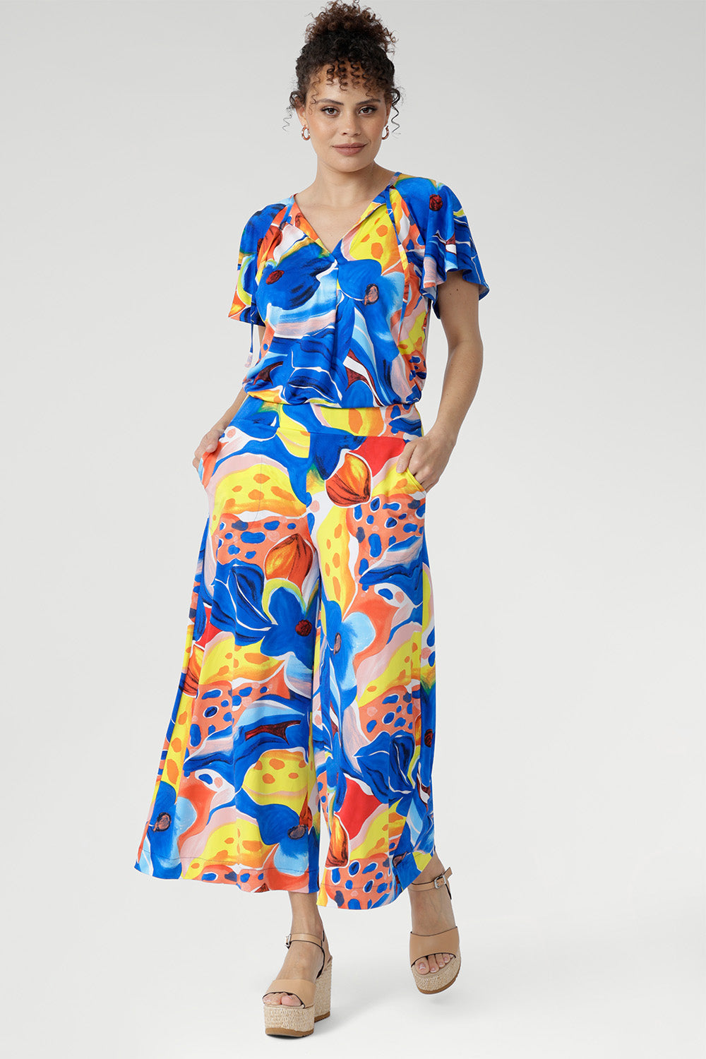 The Dany Culotte in Summer Bliss is crafted from cool-touch slinky jersey and printed with a bold abstract design. With a wide-leg shape for movement and a soft pull-on waistband for comfort, it’s the perfect mix of style and ease. Complete with side pockets, this culotte is ideal for work, travel, and weekend wear.