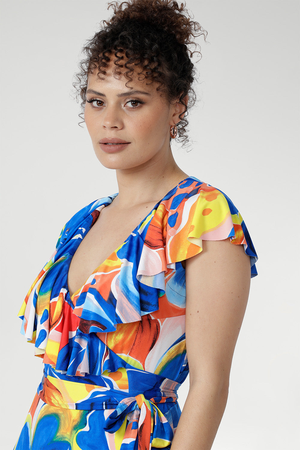 In cool-touch slinky jersey, the Elle Maxi Wrap Dress in Summer Bliss offers effortless elegance. The wrap silhouette with tie waist flatters every shape, while a raw edge frill and abstract floral print add a modern touch. Complete with pockets and a double-layered back for comfort — ideal for summer parties and relaxed days.