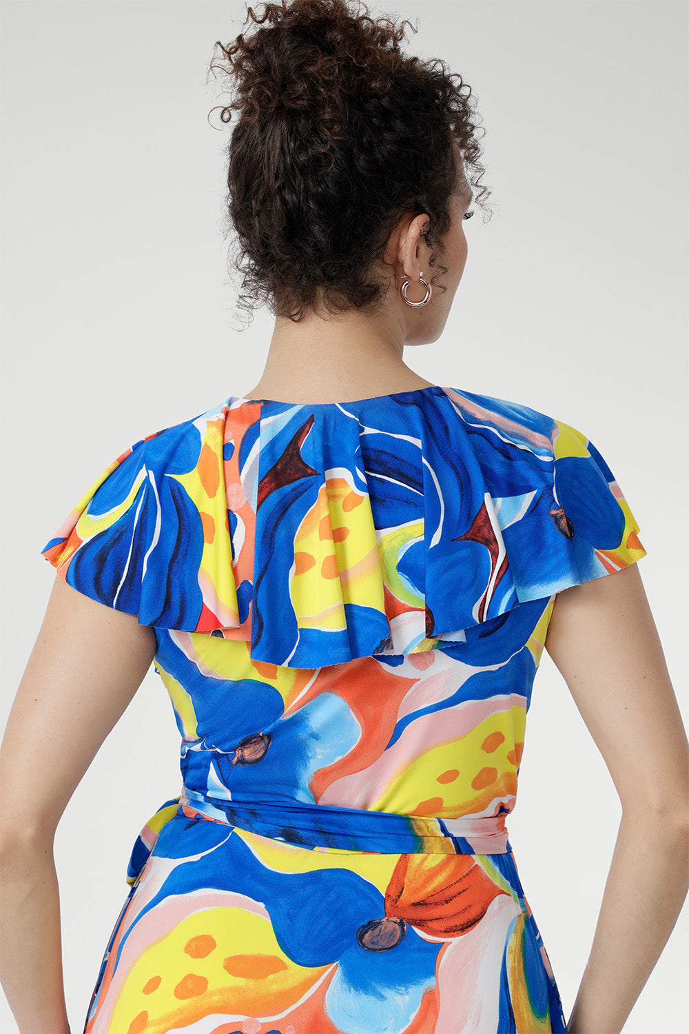 Crafted from cool-touch slinky jersey, it features a flattering wrap design with a tie waist and a laser-cut raw edge frill that lends a light, contemporary edge. Finished in a bold abstract floral print, with pockets and a double-layered back for comfort, it’s the perfect piece for festive summer occasions.